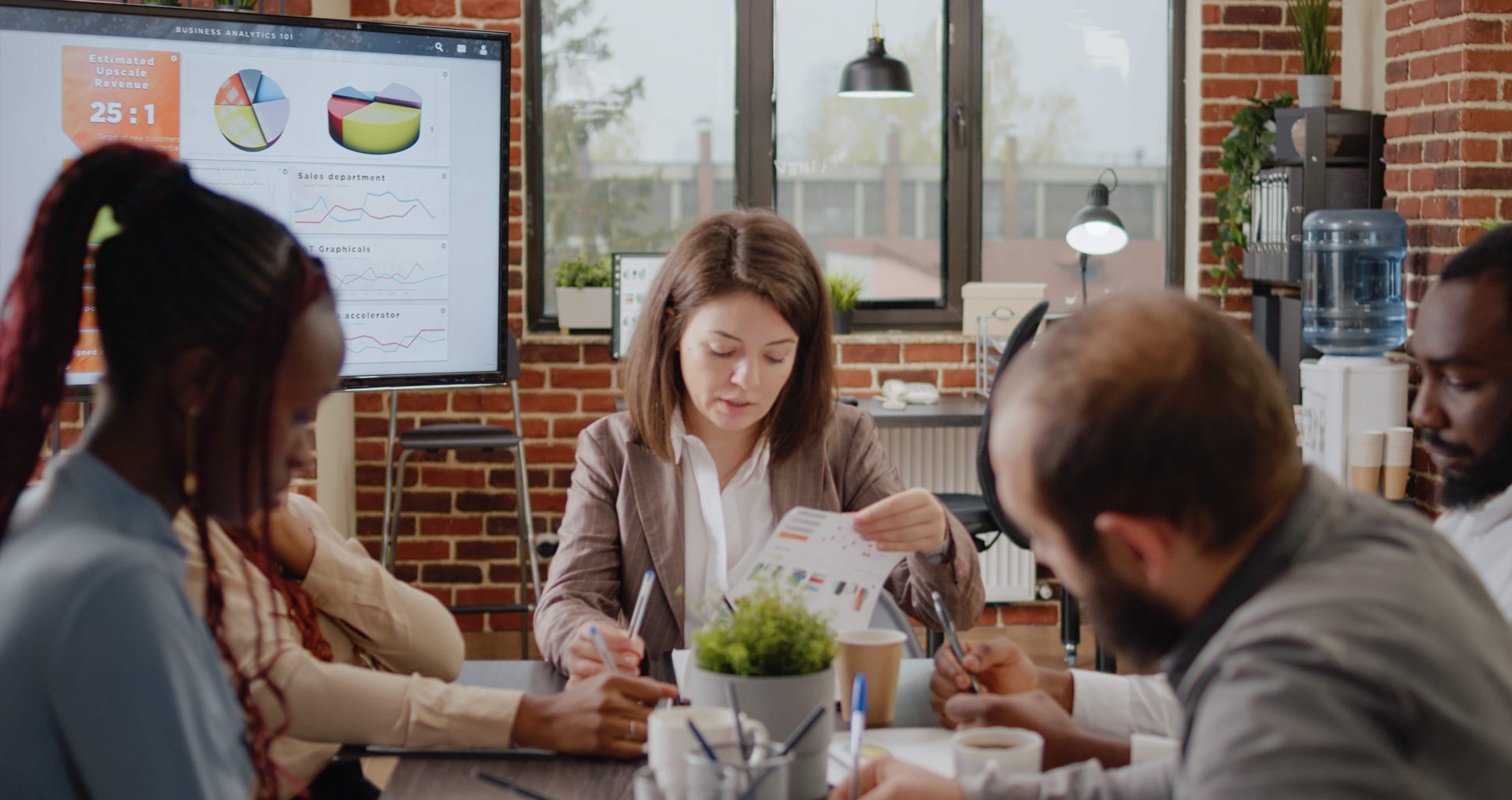 Diverse group of workmates discussing business strategy in startup office. Colleagues working on project planning and presentation for company development and growth. Brainstorming ideas